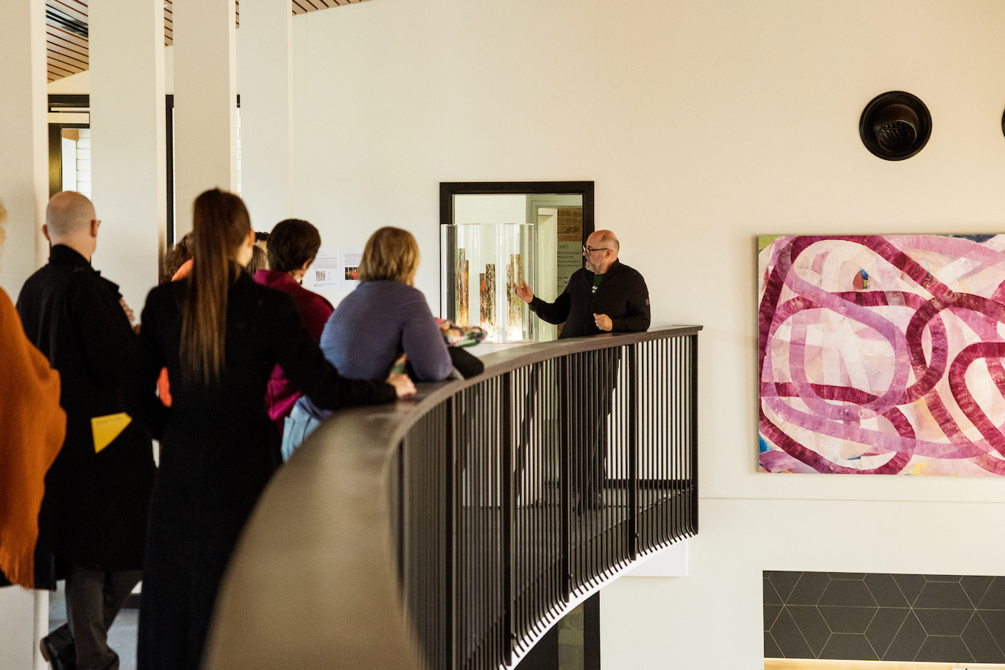 Professor Simon Haberle, Director of the School of Culture, History and Language (CHL) Simon Haberle explaining an artwork on a balcony with a crowd watching