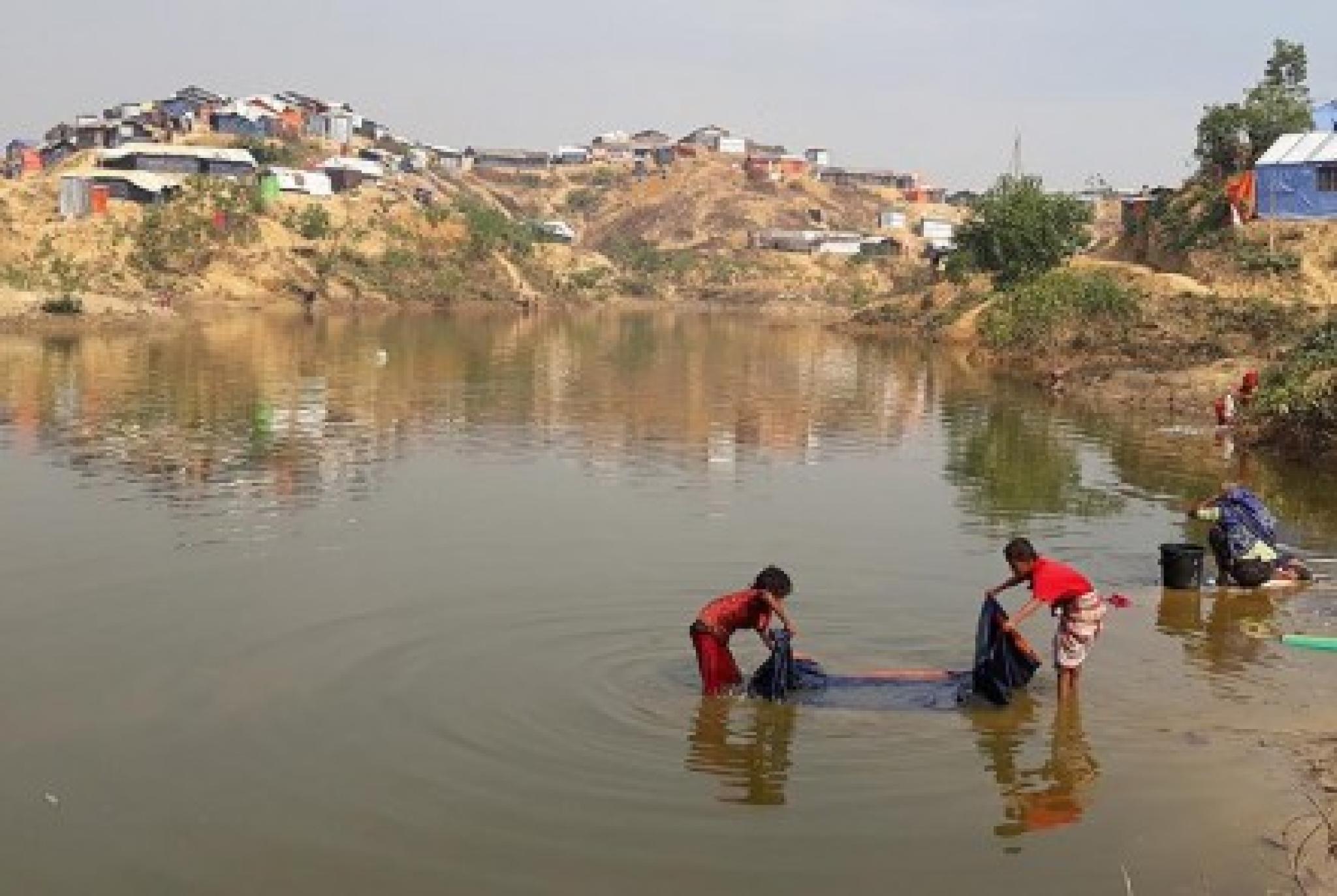 Refugee children washing in pond