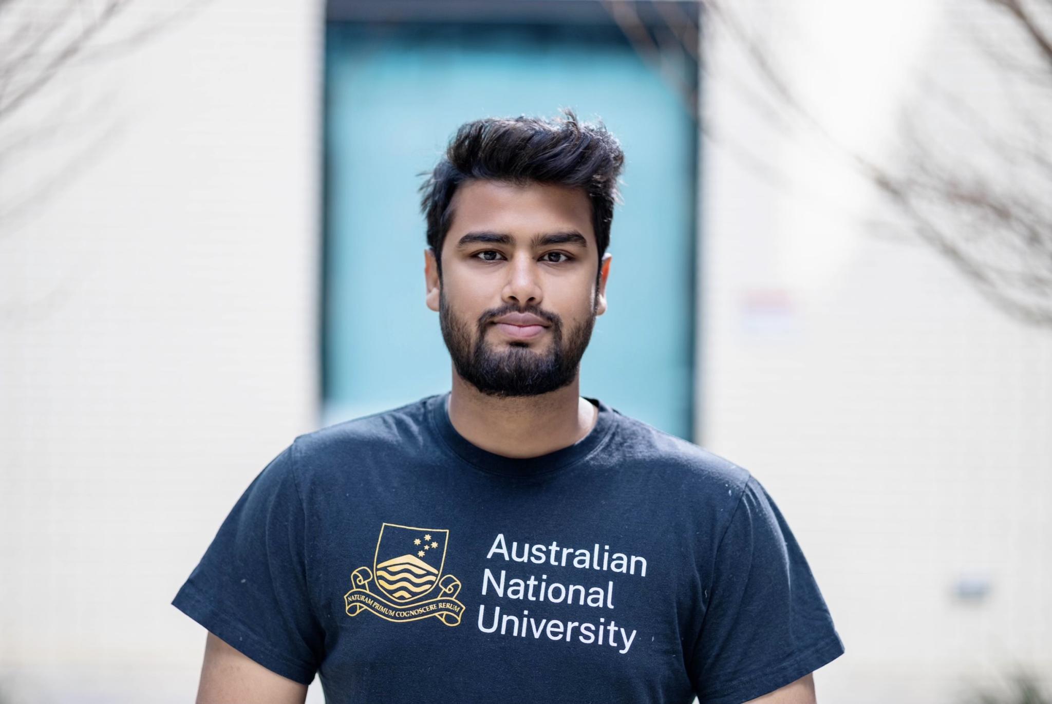 Student Sai Hossain looking at camera wearing an ANU shirt