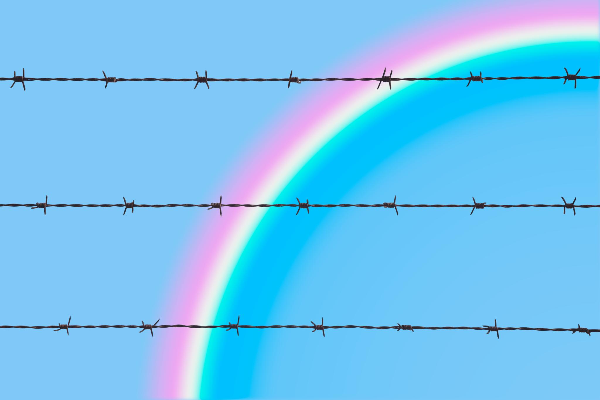 A barbed wire fence with a rainbow.