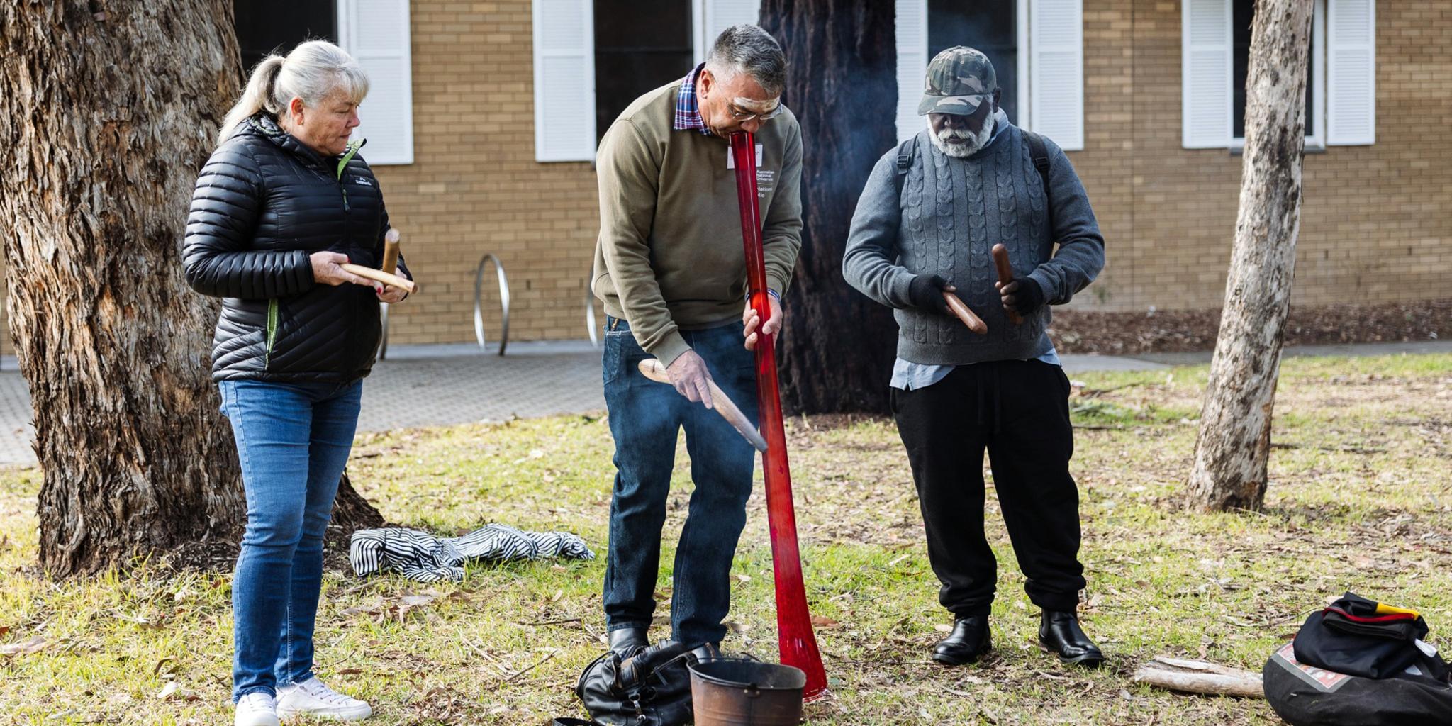 Paul House (middle), a senior Ngambri-Ngunnawal custodian of the Canberra region, performs the Welcome to Country ceremony.