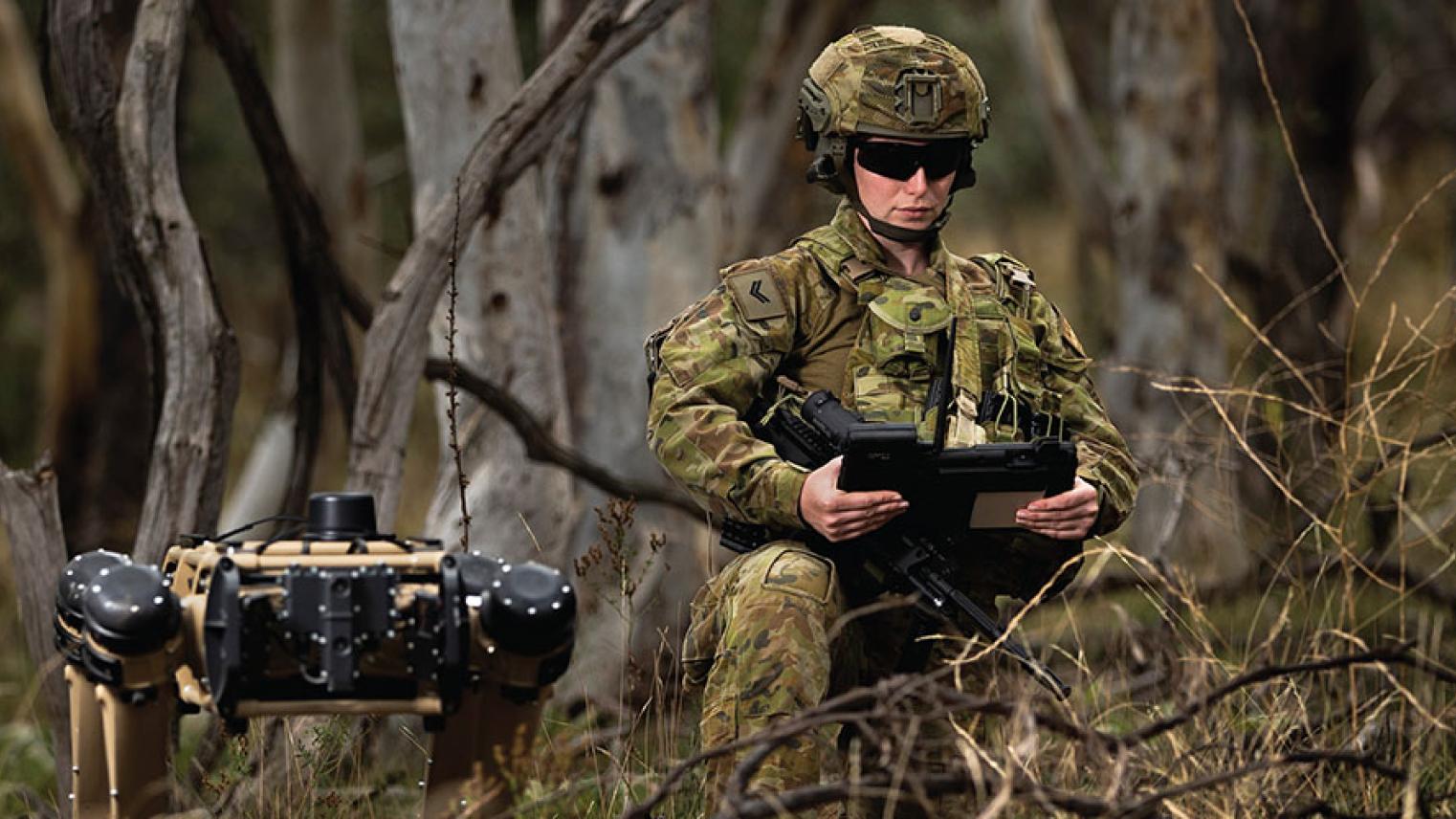 Soldier with robot canine in the bush